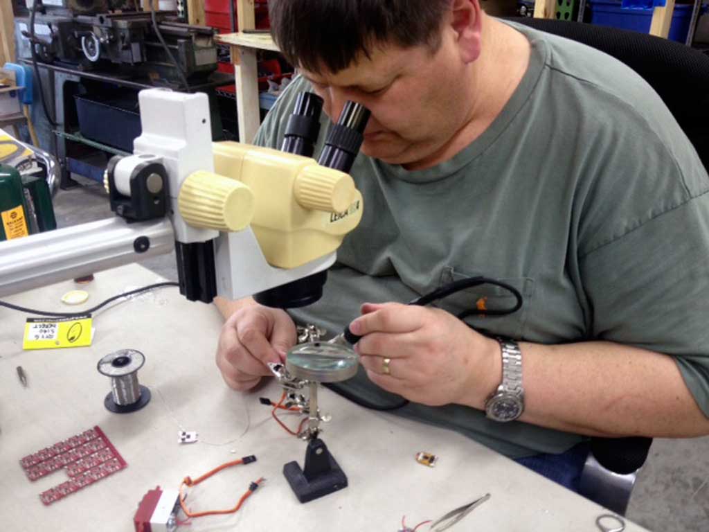 Close up photo of Pertti soldering on a PCB card